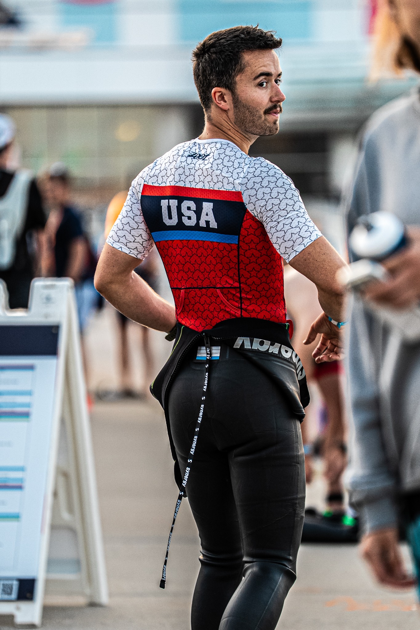 Triathlete in a USA race kit looking back during a competition transition