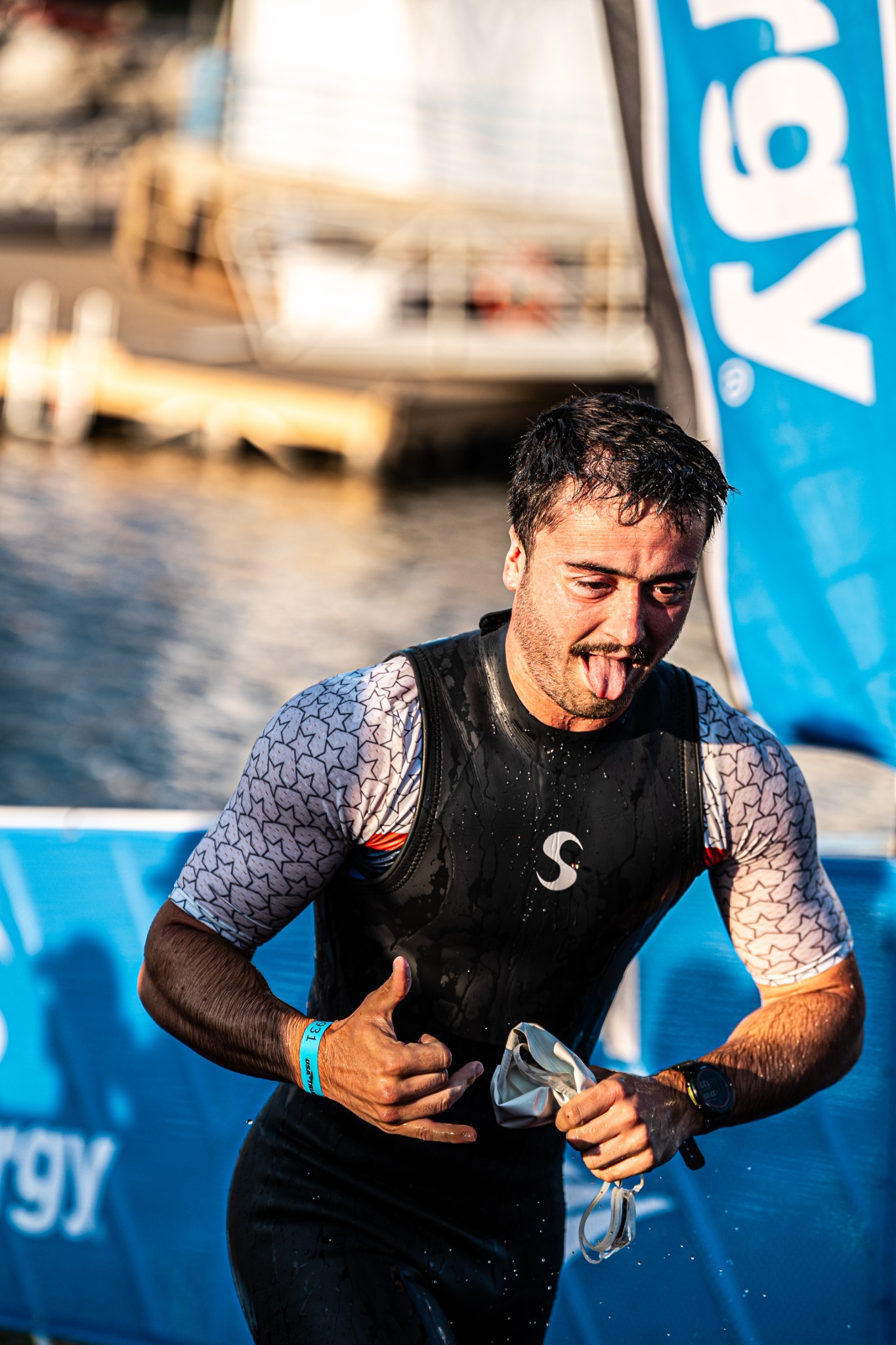 Triathlete emerging from the swim and gesturing toward the camera